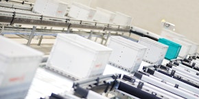 roll of sheet steel, transported by crane at the factory