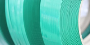 roll of sheet steel, transported by crane at the factory